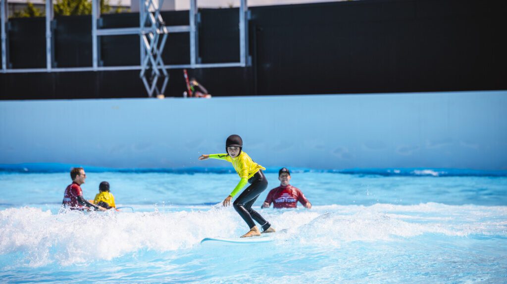 Surfer riding a perfect, machine-shaped wave at The Point Surf Park in Fellsmere, Florida