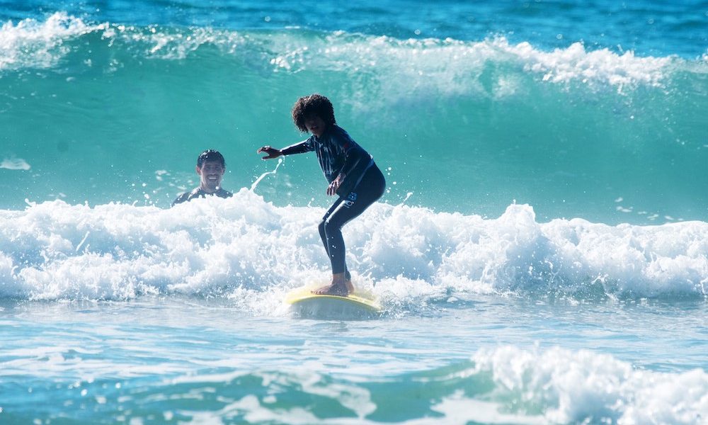 Beginner surfer on a soft-top board during a coached session at The Point Surf Park in Fellsmere, Florida